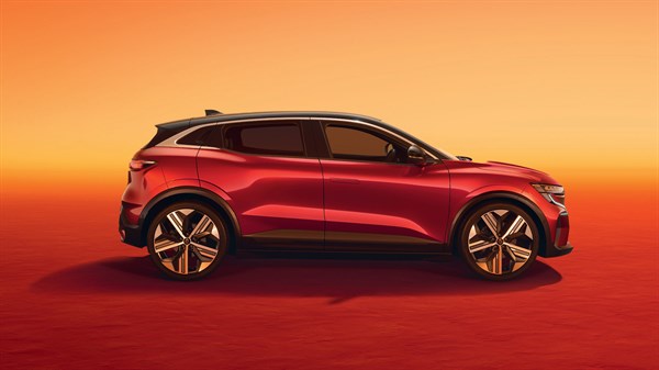 Profil vozila Megane E-Tech electric snimljenog sa strane u studiju s narančasto-crvenom pozadinom.


