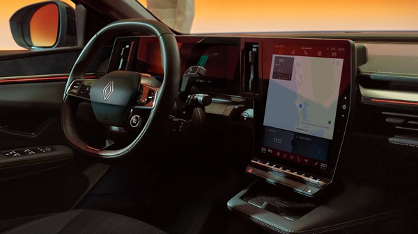 Unutrašnjost vozila Megane E-Tech electric s fokusom na upravljač i veliki okomiti središnji zaslon s prikazom navigacije, snimljena u ambijentalnom narančastom svjetlu.








