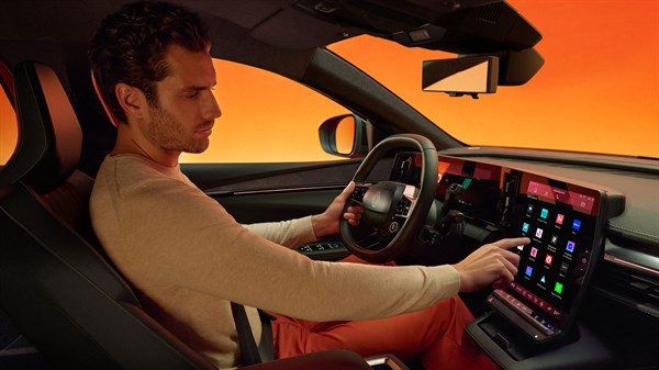 unutrašnjost vozila Renault Megane E-Tech electric s vozačem koji koristi središnji zaslon i upravlja sustavom