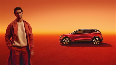 Crveno vozilo Megane E-Tech electric parkirano u studijskom prostoru, pred njim stoji muškarac.








