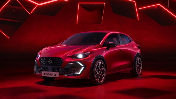 Novi Renault Clio u crvenoj boji, snimljen sprijeda pod kutom, u prostoru s crvenom rasvjetom i modernim linijama.