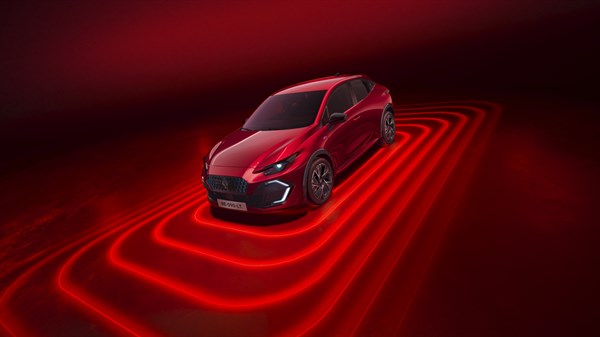 Novi Renault Clio u crvenoj boji prikazan sprijeda, s naglašenim sigurnosnim sustavima i crvenim svjetlosnim efektima oko vozila.