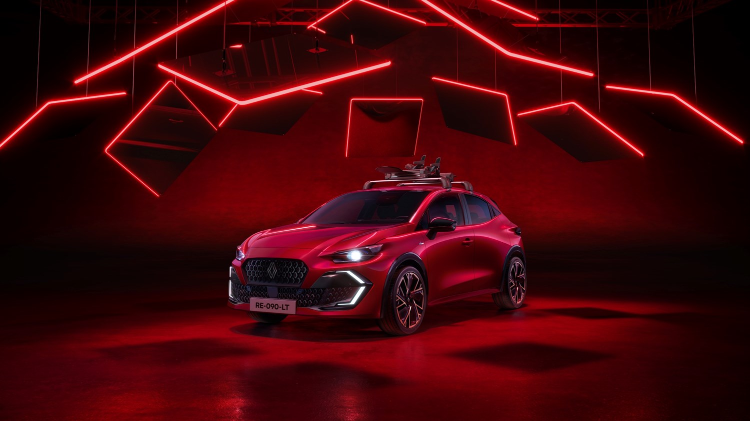 Vozilo Renault Clio prikazano u zatvorenom prostoru s intenzivnom crvenom rasvjetom, snimljeno sprijeda s naglaskom na prednju masku, sportske linije i osvijetljene LED detalje, uz krovne nosače postavljene na krovu vozila.