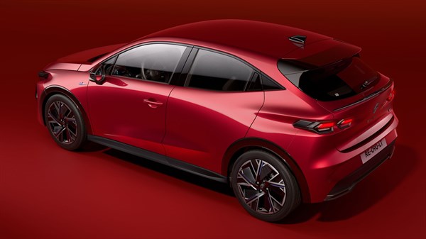 Vozilo Renault Clio prikazano iz stražnjeg bočnog kuta u zatvorenom prostoru s crvenom rasvjetom, s naglaskom na stražnji spojler, sportske linije i detalje karoserije.