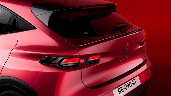 Stražnji dio vozila Renault Clio prikazan u crvenom ambijentu, s naglaskom na crni stražnji spojler i LED stražnja svjetla.