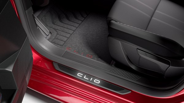Unutrašnjost vozila Renault Clio prikazana uz aluminijske osvijetljene pragove i tamne podne prostirke, snimljeno iz donjeg bočnog kuta pri otvorenim vratima.