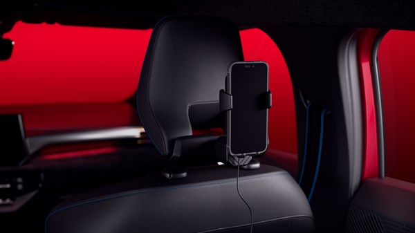 Pametni telefon postavljen na YouClip induktivni bežični punjač na naslonu za glavu u vozilu Renault Clio, prikazan iz stražnjeg dijela kabine.