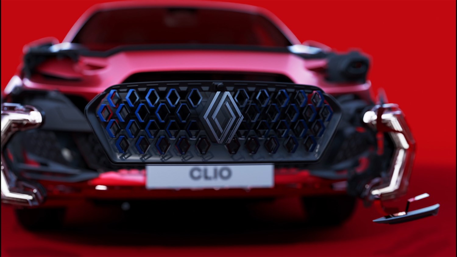 Prednji dio vozila Renault Clio s istaknutom maskom hladnjaka i prepoznatljivim Renault logotipom u sredini, na crvenoj pozadini.