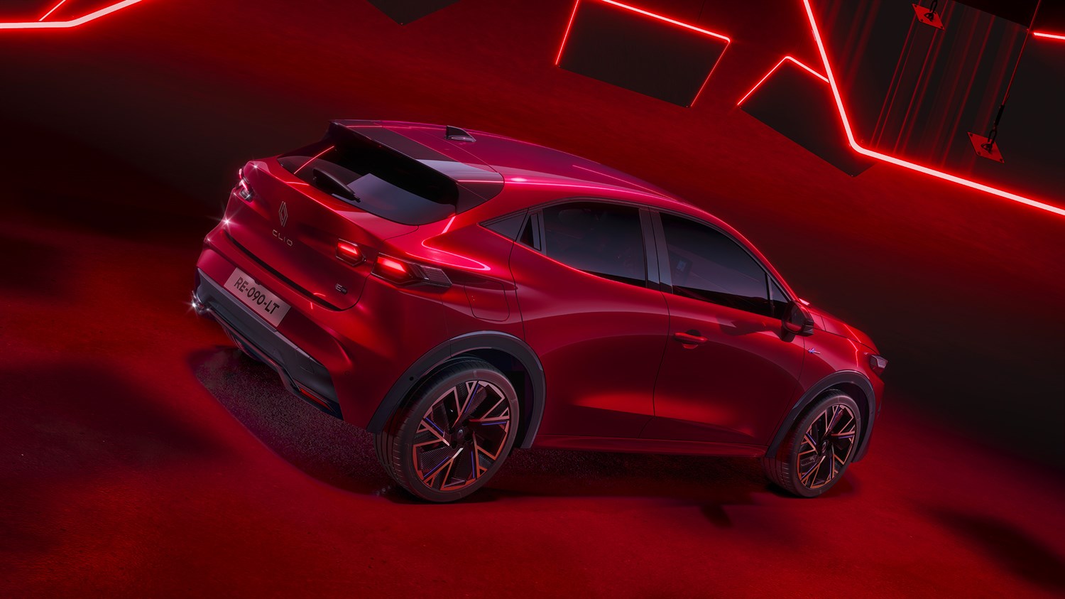 Stražnji i bočni pogled na crveno vozilo Renault Clio s modernim LED svjetlima i sportskim linijama karoserije, prikazano u crvenom ambijentalnom osvjetljenju.