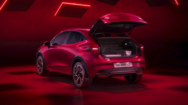 Vozilo Renault Clio s otvorenim prtljažnikom u crveno osvijetljenom prostoru.