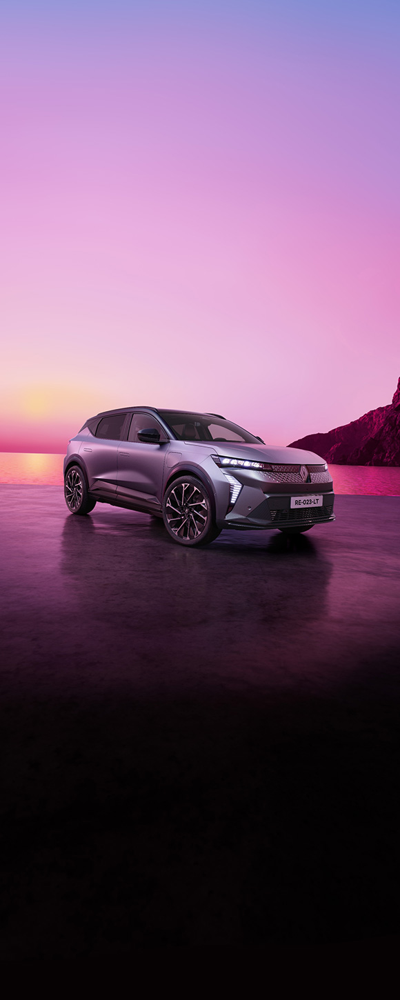 Renault Scenic na mokroj obalnoj površini pri zalasku sunca, s ružičastim nebom i morem u pozadini.