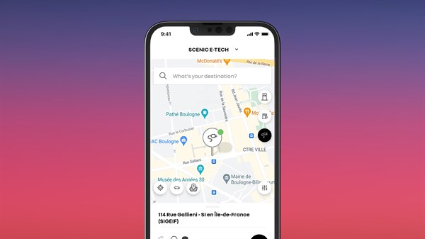 Pametni telefon s aplikacijom My Renault na zaslonu, koji prikazuje kartu s pretraživanjem punionica za vozilo Renault Scenic E-Tech electric.