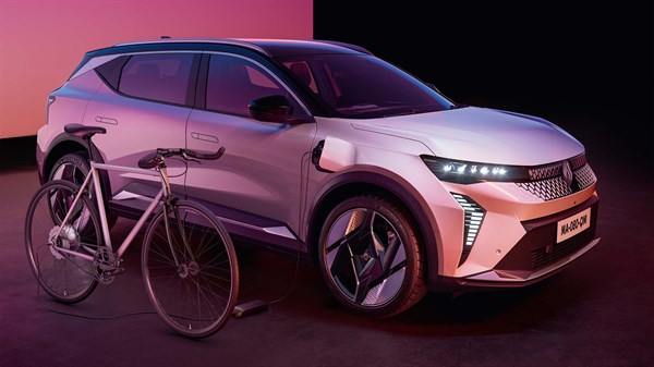 Scenic E-Tech electric s bijelim biciklom naslonjenim i ružičastom pozadinom.
