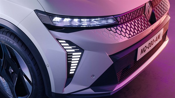 Bijeli Renault Scenic s prednje strane na ružičastoj pozadini.