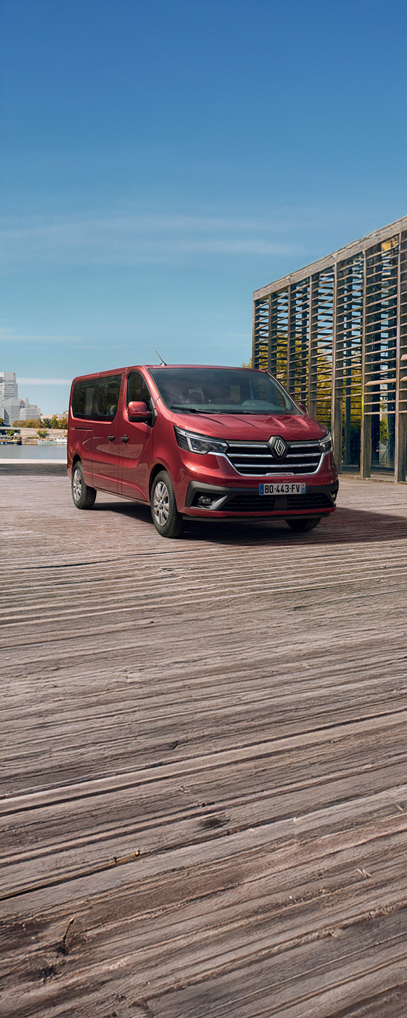  Vozilo Trafic Passenger parkirano uz urbani pejzaž, prikazano u Carmine Red boji.