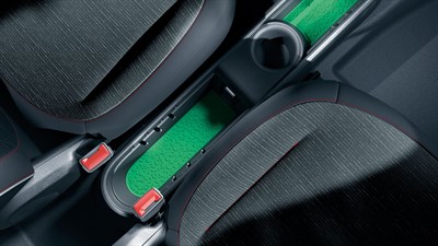 Pogled na središnju konzolu u vozilu Renault Twingo E-Tech electric s alfabet prostirkom u zelenoj boji između prednjih sjedala.