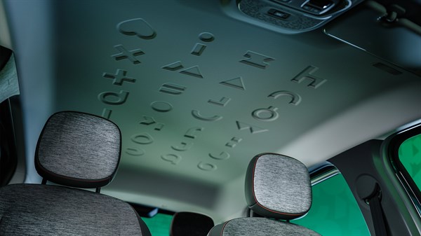 Unutrašnjost vozila Renault Twingo E-Tech electric s vidljivim reljefnim uzorcima i tipografijom na oblozi krova