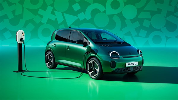 Vozilo Renault Twingo E-Tech electric priključeno na AC punionicu na javnom parkirnom mjestu, s vidljivim kabelom za punjenje i prednjim bočnim pogledom na vozilo.