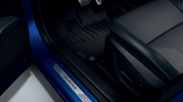 Tepisi esprit Alpine u unutrašnjosti vozila Captur full hybrid E-Tech s plavim prošivima i aluminijskim pragom s oznakom Alpine.


