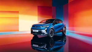 Renault Captur u tričetvrtinskom pogledu u studijskom okruženju s narančasto-crvenim pozadinama, s odrazom na sjajnoj podlozi.
