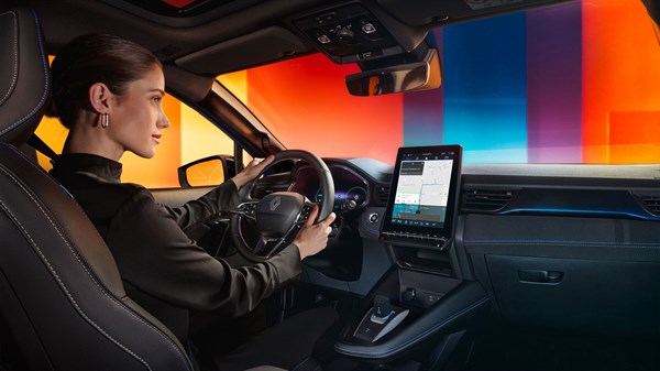 Vozačica u vozilu Captur full hybrid E-Tech koristi središnji multimedijski ekran s aplikacijama.