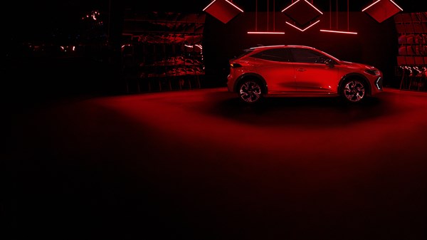 Vozilo Austral full hybrid E-Tech parkirano na otvorenom prostoru u suton, prikazano sprijeda i sa strane.