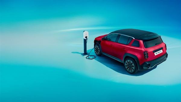 Renault 4 E-Tech electric vozilo spojeno na punionicu na plavoj pozadini

