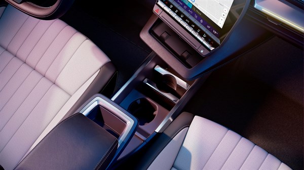 Središnja konzola između prednjih sjedala vozila Renault Scenic E-Tech s pretincima za pohranu i držačima za čaše.