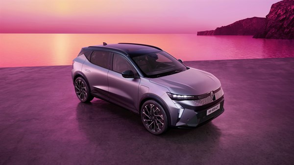 Renault Scenic prikazan iz prednjeg gornjeg kuta uz obalu, okružen ružičasto-ljubičastim krajolikom mora i stijena.