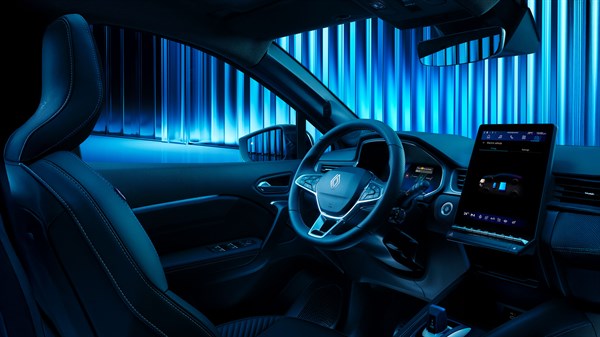 Pogled iz stražnjih sjedala na unutrašnjost vozila Renault Symbioz full hybrid E-Tech s istaknutim digitalnim zaslonima i plavim ambijentalnim osvjetljenjem.

