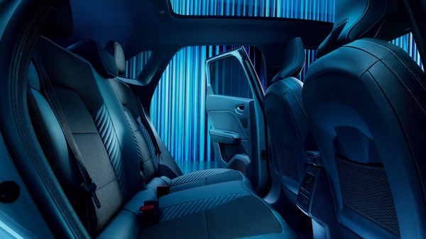 unutrašnjost vozila Renault Symbioz, prikaz stražnje pomične klupe s pomaknutim sjedalima za povećanje kapaciteta prtljažnika, plava pozadina

