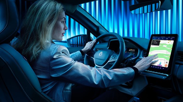 Žena sjedi za upravljačem Renault vozila i koristi veliki zaslon osjetljiv na dodir s navigacijom.
