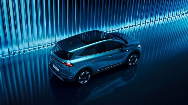 Pogled odozgo na vozilo Renault Symbioz full hybrid E-Tech parkirano u plavom studiju s vidljivim panoramskim krovom.