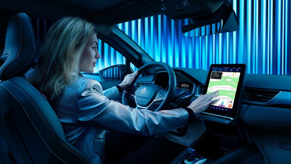 Žena u vozilu Renault Symbioz full hybrid E-Tech koristi središnji zaslon za navigaciju.