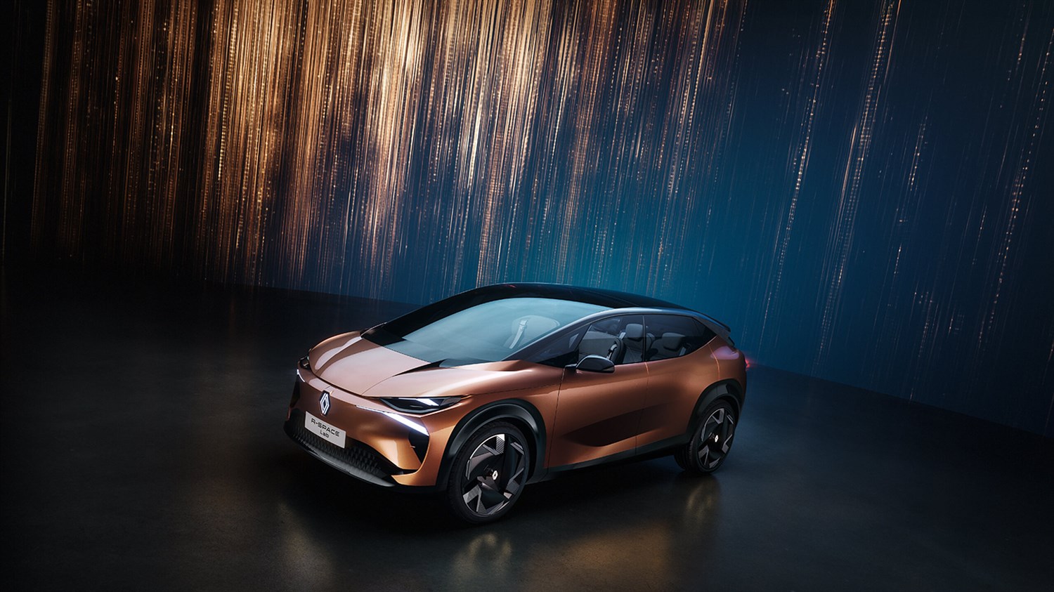konceptno vozilo Renault R-Space Lab u studijskom okruženju s bakrenom karoserijom i velikim panoramskim staklom na krovu, prikazano na tamnoj pozornici sa svjetlosnom pozadinom