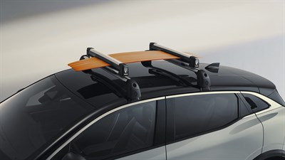 Vozilo Megane E-Tech electric s montiranim krovnim nosačima i narančastim teretom na krovu, snimljeno u profilu.


