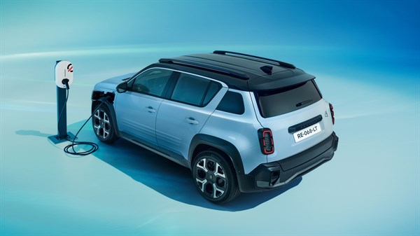 Plavo električno vozilo Renault 4, pogled odostraga u tričetvrtinskom kutu, priključeno na punionicu na plavoj pozadini.